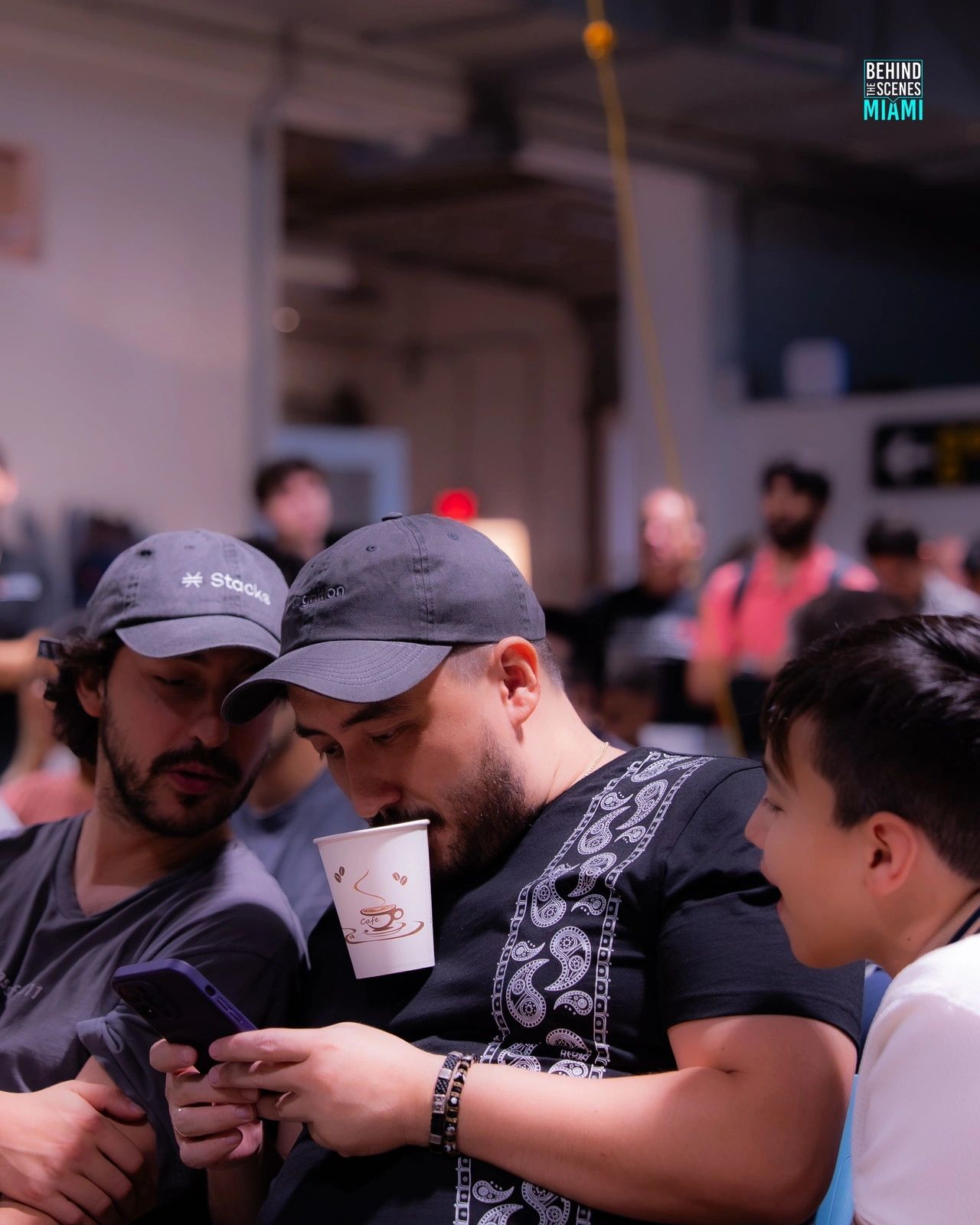 Coffee in one hand, the plan in the other: hackers compare notes mid-build.